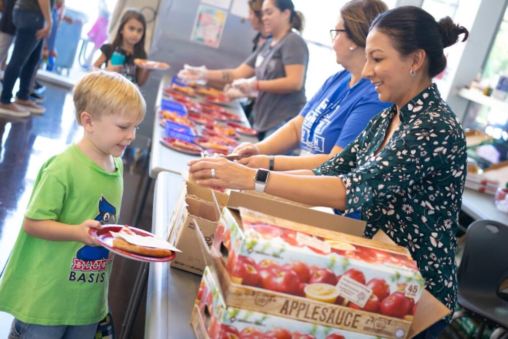 Parent volunteers serving lunch to BASIS primary school students