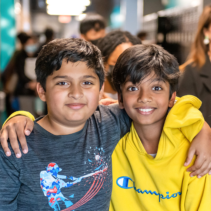 boy, boys, group, group of students, three students, hallway, Indian, Indian boy, smiling, facing camera, chin diaper, mask, masked student, happy, lockers