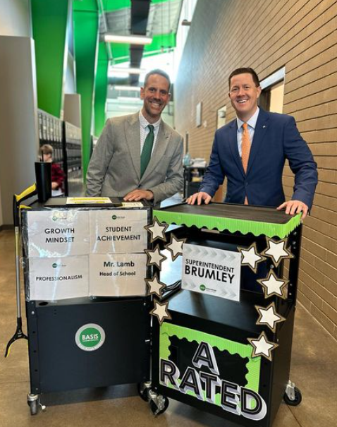 BASIS Baton Rouge Materra Head of School Jared Lamb with Louisiana State Superintendent Cade Brumley. Both are standing behind rolling carts decorated with inspirational mottos. 