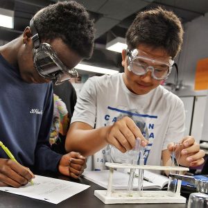 Two high school boys completing a science experiment together